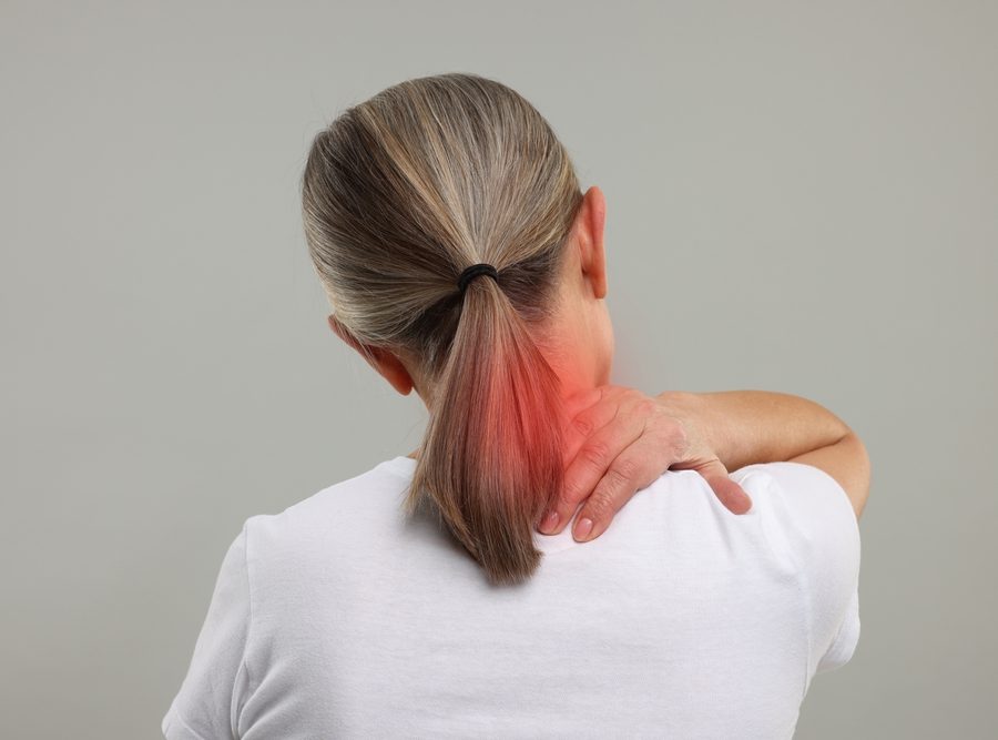 Woman,Suffering,From,Neck,Pain,On,Grey,Background,,Back,View