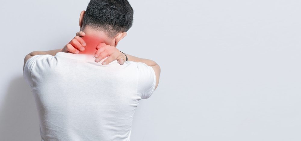 Close up of person with shoulder and neck problems, sore man touching his shoulder on isolated background, lumbar and muscular problems concept